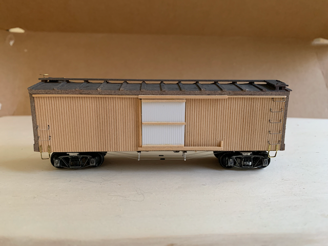 Assembled, unpainted HO scale box car, side view.