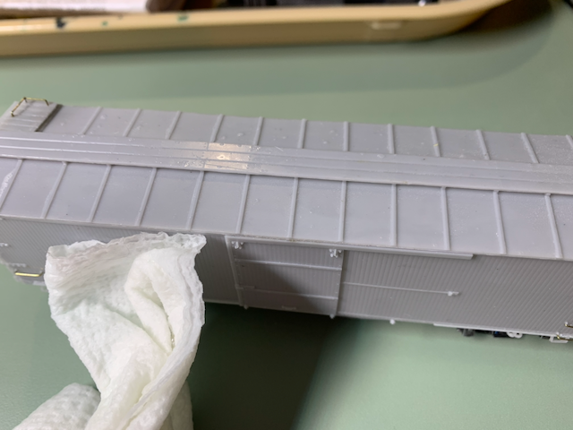 HO scale box car being washed with a damp paper towel.