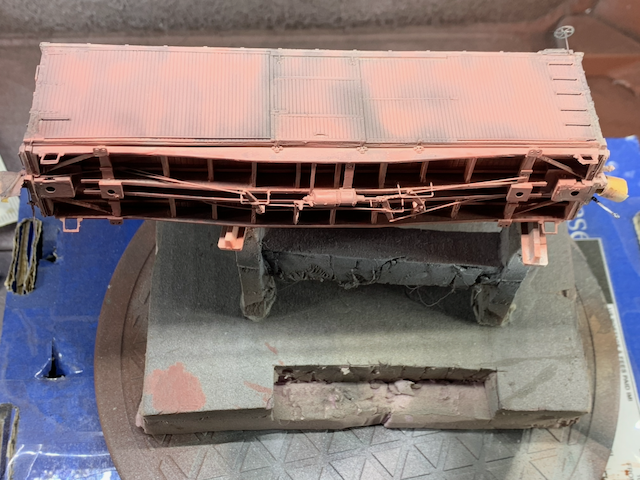 HO scale box car with dark highlighting and a layer of pink.