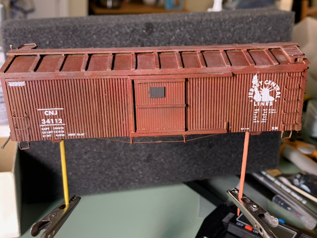 Fully painted HO scale wooden box car with CNJ decals applied and roof weathering begun.