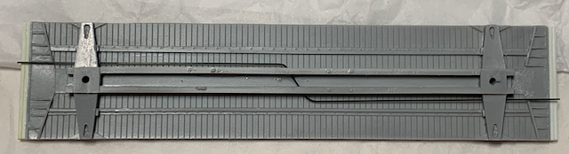 Resin HO scale box car floor with trainline installed.