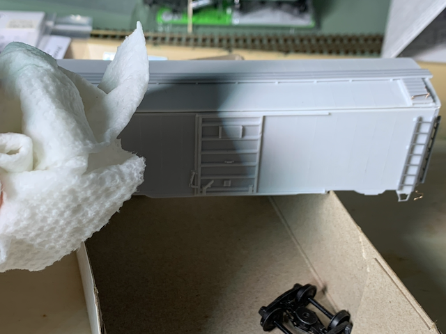 Washing an HO scale box car in preparation for painting.