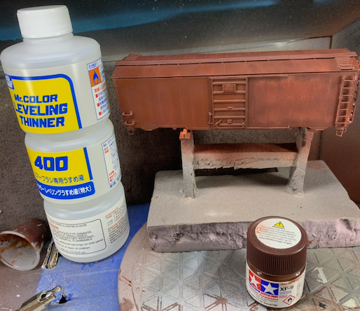 HO scale box car being spot repainted with Tamiya XF-9 hull red.