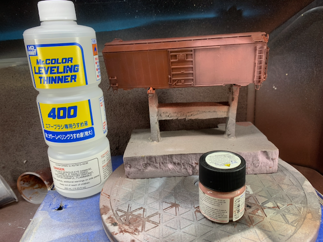 HO scale box car being spot repainted with brownish pink.