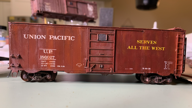 HO scale UP box car, weathered. View of the side that reads, "SERVES ALL THE WEST".